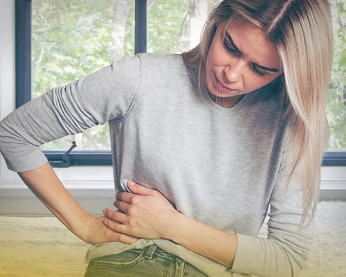 Девушка держится за больной бок